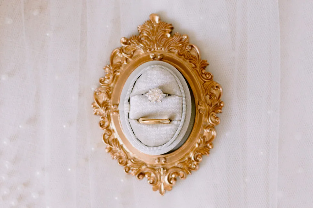 Wedding rings arranged inside an ornate gold frame