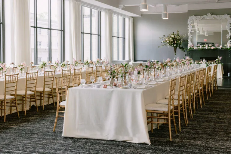 Elegant wedding reception tables prepared beside large windows