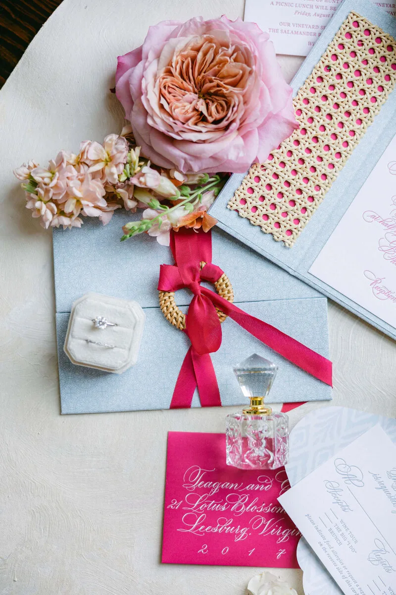Pink roses, a wedding invitation, and an engagement ring