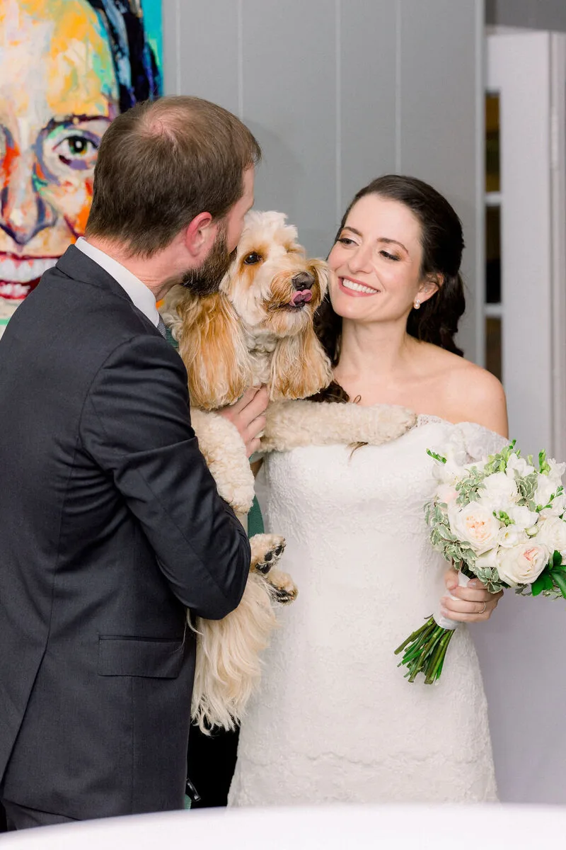 Newlywed couple sharing a reception moment with their dog