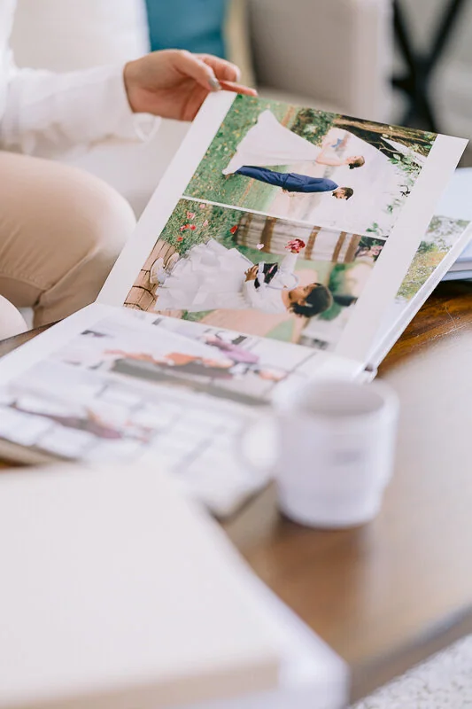 Handmade wedding album on a wooden table beside a cup of coffee