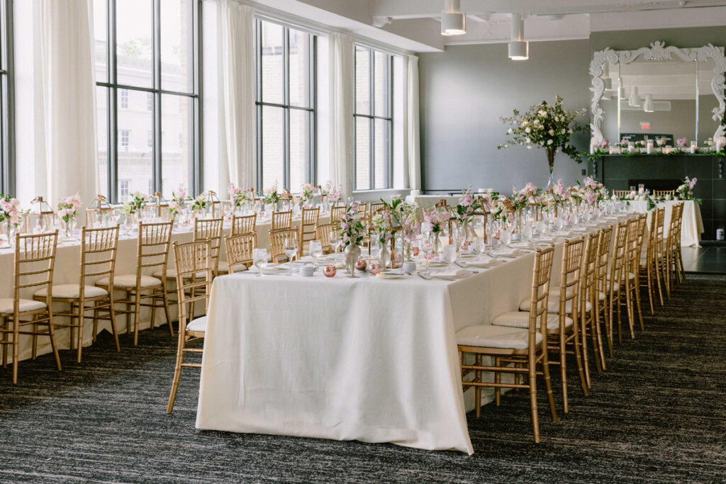 A beautifully decorated wedding table with white linens and gold chairs at Hotel Washington in Washington DC.