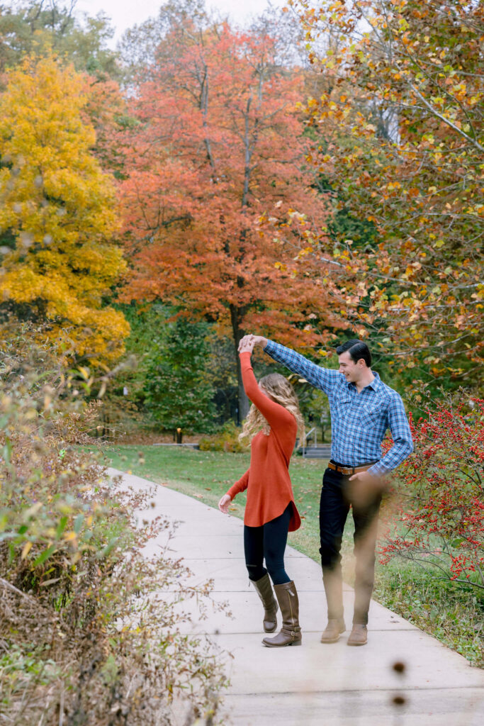 The botanical gardens provide a stunning backdrop for engagement photos as a couple twirls and dances amidst the vibrant flora at Brookside Gardens.