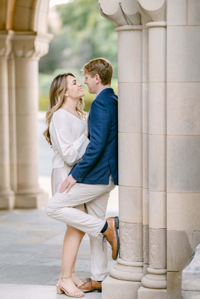 An intimate close-up of an engaged couple at the Washington's National Cathedral, leaning on a column's base, exuding elegance and romance, captured by Get Ready Photo, experienced Washington DC wedding photographers.